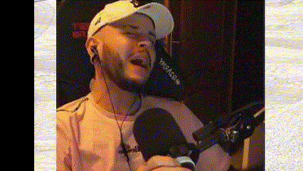 a man is singing into a microphone while wearing headphones .