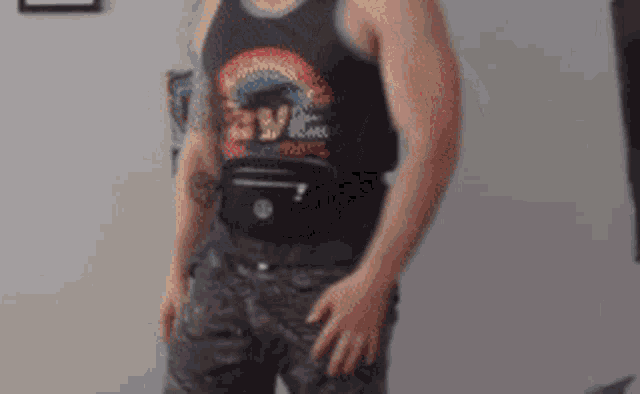 a man wearing a black tank top with a rainbow and the word love on it