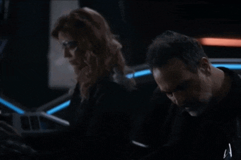 a man and a woman standing next to each other in a dark room