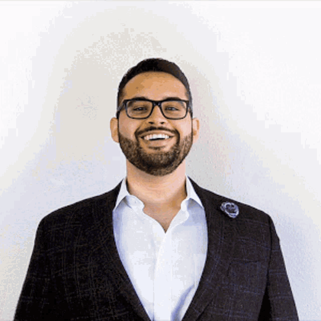 a man with a beard and glasses is smiling