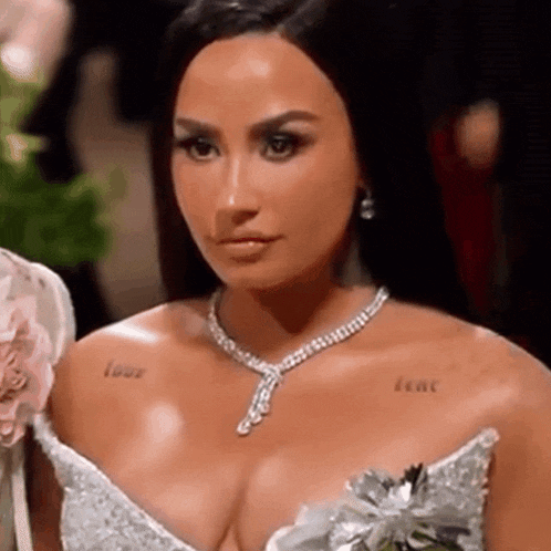 a close up of a woman wearing a necklace and a dress .