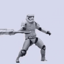 a storm trooper is holding a sword in his hand while dancing .
