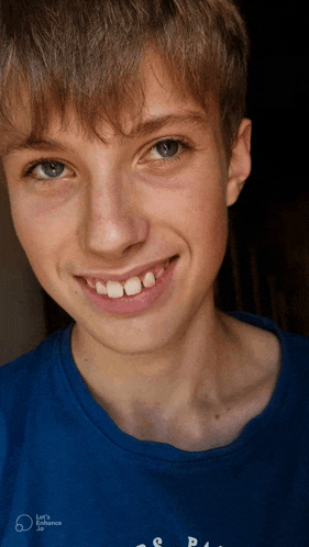 a young boy wearing a blue shirt that says let 's romance on it