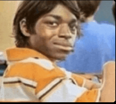a man in a striped shirt is making a funny face in a classroom .