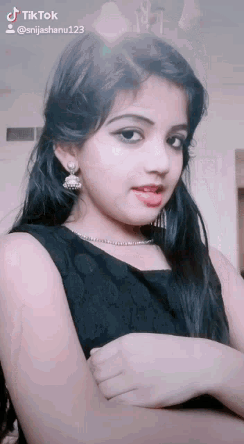 a girl in a black dress has a tiktok watermark on her face