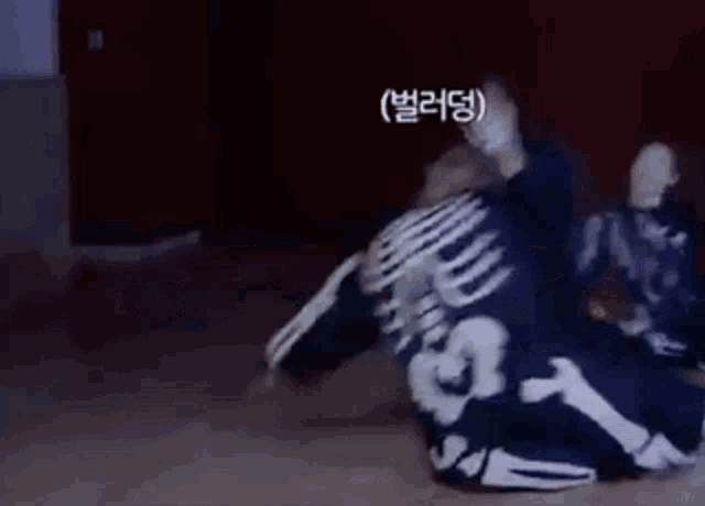 a man in a skeleton costume is laying on the floor in a dark room .