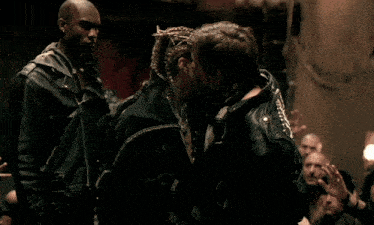 a man with a crown of thorns on his head is kissing another man