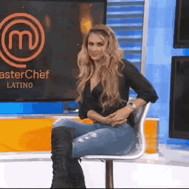 a woman is sitting on a chair in front of a master chef latino logo .