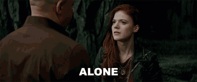 a woman with red hair is talking to a man and the word alone is visible