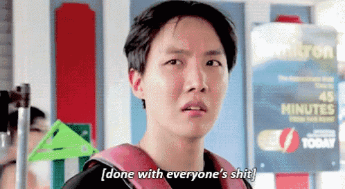 a young man with a backpack is standing in front of a sign that says done with everyone 's shit .