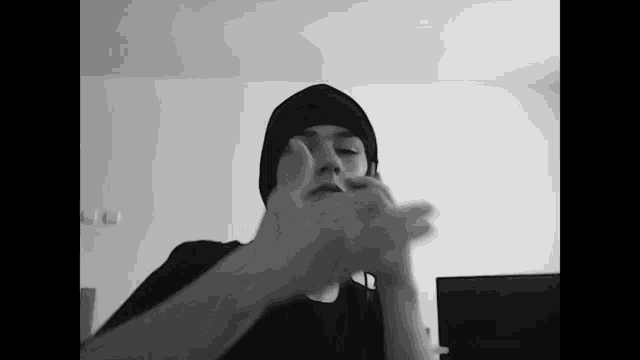 a black and white photo of a person wearing a black hat