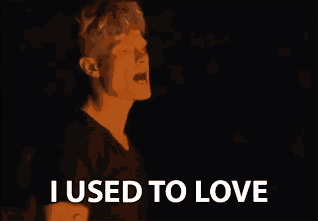 a man singing in the dark with the words i used to love above him