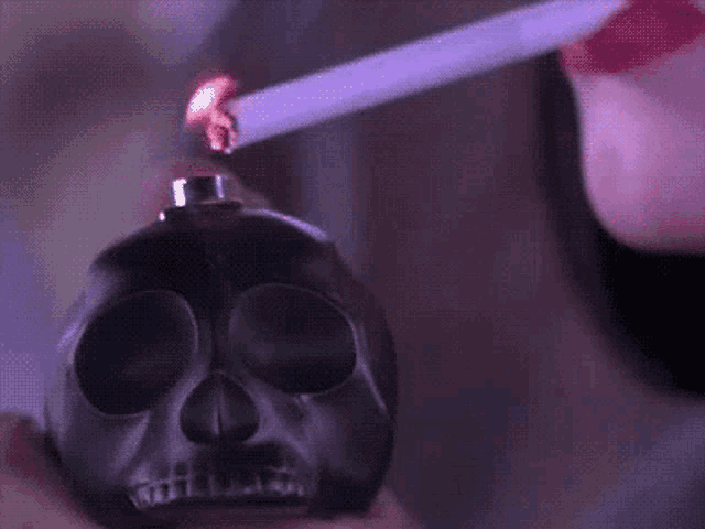 a woman lighting a cigarette with a skull shaped lighter
