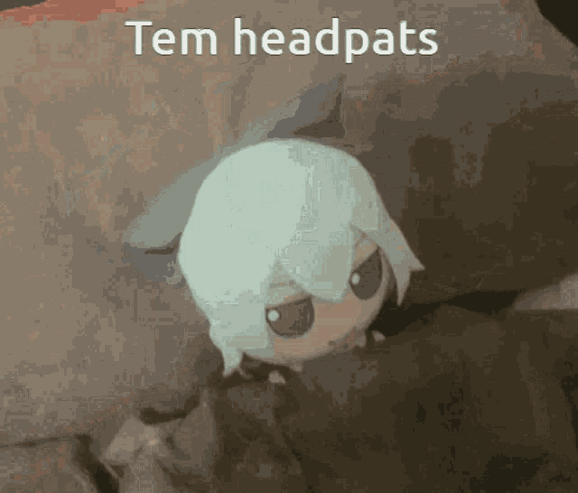 a picture of a stuffed animal with the words tem headpats written above it .