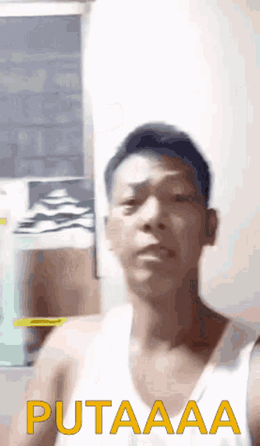 a man in a white tank top says " putaaaa " in yellow letters