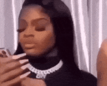 a woman with long nails is taking a picture of herself with her phone .
