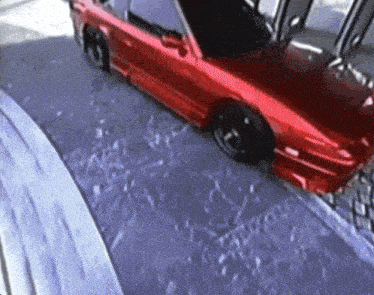 a red car is parked on a snowy road
