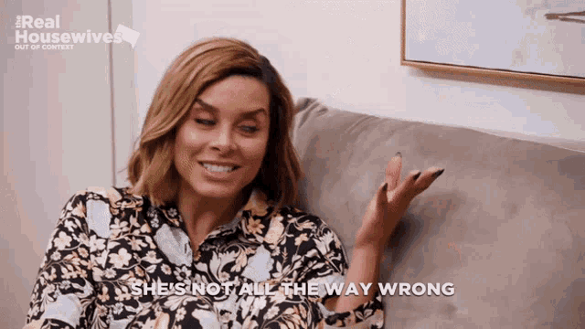 a woman sitting on a couch with the words she 's not all the way wrong above her