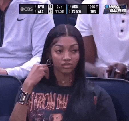 a woman wearing a t-shirt that says from bal is watching a basketball game on cbs
