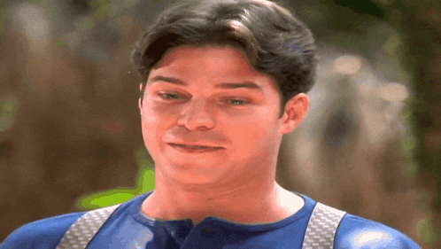 a man wearing suspenders and a blue shirt is looking at the camera