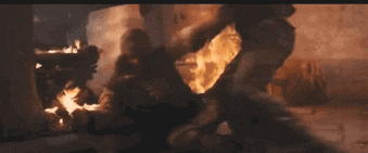 a person is standing in front of a large fire .