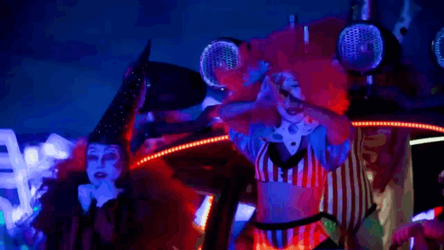 a woman in a clown costume screams with her arms in the air
