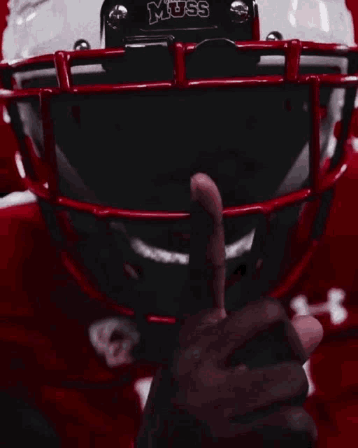 a close up of a football player wearing a helmet with the word muss on it
