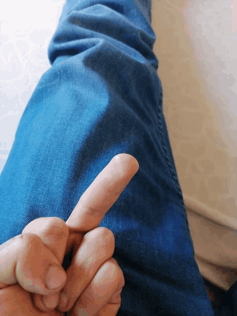 a person 's thumb is pointing to their leg