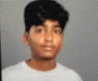 a young man in a white shirt is looking at the camera .