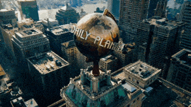 a globe on top of a building with the words daily planet written on it