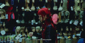 a woman with red hair is standing in front of a display of mannequins