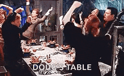 a group of people are dancing around a table with the words doug 's table on it .