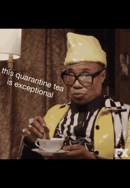 a man wearing glasses and a yellow hat is holding a cup of tea and says this quarantine tea is exceptional