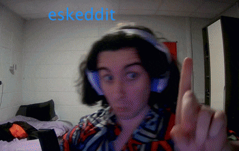 a person wearing headphones is giving the middle finger in front of a sign that says eskudit