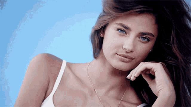 a close up of a woman 's face with a blue sky in the background
