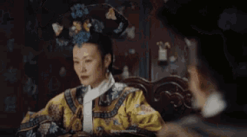 a woman in a traditional costume is making a funny face while wearing a hat .
