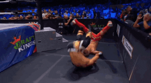 two men are wrestling in a ring with the word impact kings on the wall