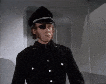 a man wearing a black hat and eye patch