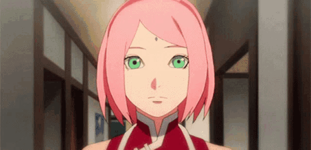 a girl with pink hair and green eyes is walking down a hallway .