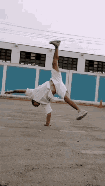 a man in white shorts is doing a handstand
