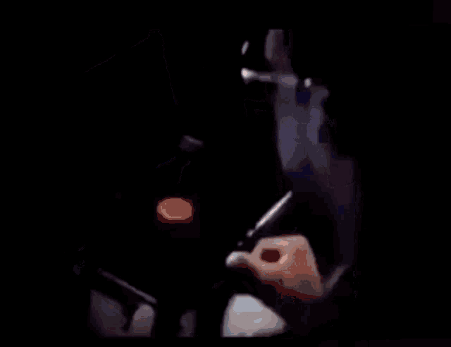 a person is typing on a laptop in the dark .