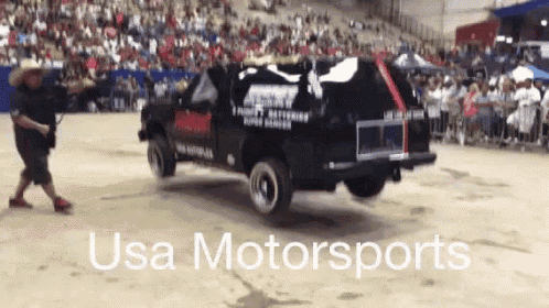 a man is pushing a truck that says usa motorsports on the side