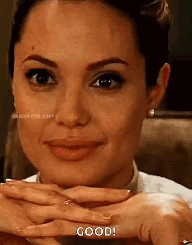 a close up of a woman 's face with her hands folded and a caption that says `` good '' .