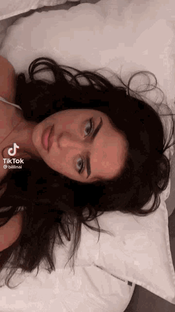 a woman is laying on a bed with a tiktok watermark