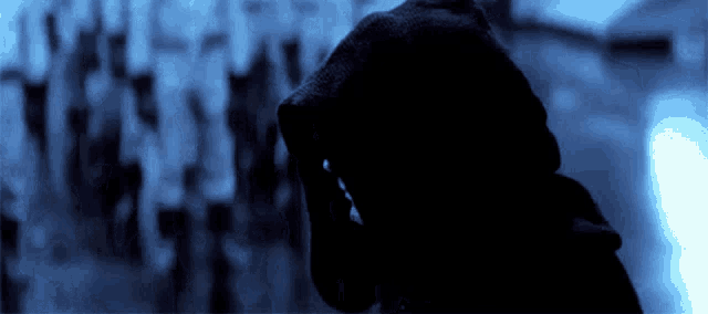 a person in a hooded sweatshirt with their hand on their face