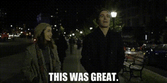 a man and a woman are standing on a sidewalk at night with the words this was great written on the bottom .