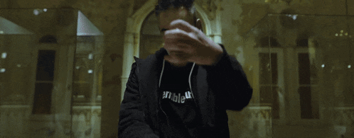 a man wearing a terrible t-shirt points his finger at the camera
