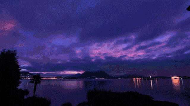 a sunset over a lake with mountains in the distance