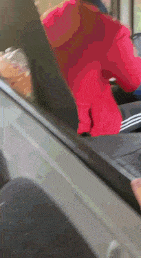 a person in a red sweater is walking on a treadmill