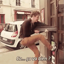a man is standing on one leg in front of a car and says ca ca va bien ?